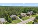 Aerial view of homes with lush greenery, mature trees, well-maintained lawns, and a long driveway at , Cumming, GA 30041