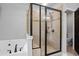 Bright bathroom featuring a large glass shower, a soaking tub, neutral tile, and built-in seating at , Cumming, GA 30041