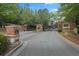 Gated community entrance with brick columns, stone accents, and mature landscaping along a paved road at , Cumming, GA 30041