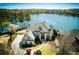 Aerial view of an estate home situated on a lake with mature trees at 1160 Lake Shore Overlook, Alpharetta, GA 30005