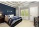 Bedroom with a blue accent wall, plantation shutters, and an inviting window seat at 1160 Lake Shore Overlook, Alpharetta, GA 30005