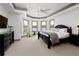 Primary bedroom with sitting area, tray ceilings, neutral carpet, and lake views at 1160 Lake Shore Overlook, Alpharetta, GA 30005