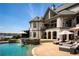 Elegant home exterior with a pool, spa, outdoor seating, and stunning waterfront views, ideal for luxury living at 1160 Lake Shore Overlook, Alpharetta, GA 30005