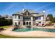 Luxury home with a pool, outdoor kitchen, and lake views creating the perfect retreat for relaxation at 1160 Lake Shore Overlook, Alpharetta, GA 30005