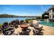 Outdoor fire pit surrounded by Adirondack chairs with lake view near pool at 1160 Lake Shore Overlook, Alpharetta, GA 30005