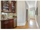 Hallway featuring a granite-topped bar area with cabinets, stainless steel appliances, and hardwood floors at 1160 Lake Shore Overlook, Alpharetta, GA 30005