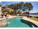 Beautiful pool featuring a basketball hoop and waterfall, surrounded by lush landscaping and waterfront views at 1160 Lake Shore Overlook, Alpharetta, GA 30005