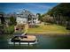 Waterfront home with a private dock and boat, featuring lush landscaping and stunning lake views at 1160 Lake Shore Overlook, Alpharetta, GA 30005