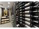 Close up view of a custom wine storage rack with a large wine collection and adjacent brick accent wall at 1160 Lake Shore Overlook, Alpharetta, GA 30005