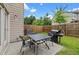 Back patio with table and chairs, privacy fence, lawn, and a grill for outdoor entertaining at 5076 Longview Walk, Decatur, GA 30035