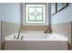 Bathroom with large bathtub, tile backsplash, and custom window at 531 Rokeby Dr, Woodstock, GA 30188