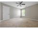 This bedroom boasts a ceiling fan, large window, and neutral walls, creating a cozy retreat at 531 Rokeby Dr, Woodstock, GA 30188