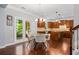 Open kitchen and dining area with hardwood floors, chandelier, granite countertops, and stainless steel appliances at 531 Rokeby Dr, Woodstock, GA 30188