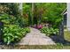 Stone pathway lined with lush greenery and flowering plants leading to the home at 531 Rokeby Dr, Woodstock, GA 30188