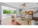 Open-concept living room with hardwood floors, large windows, and neutral-toned decor and an adjacent dining and kitchen area at 531 Rokeby Dr, Woodstock, GA 30188
