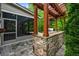Stone outdoor kitchen with pergola, grill, sink, and screened-in porch at 531 Rokeby Dr, Woodstock, GA 30188