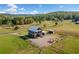 Aerial view of a charming two-story barn with rolling pastures, fencing, and mountain views at 96 Landers Ne Rd, Rydal, GA 30171