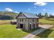Custom barn home with a metal roof, wooden exterior and a large yard with a well-maintained driveway at 96 Landers Ne Rd, Rydal, GA 30171