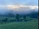 Scenic view of fenced property with lush greenery shrouded in a misty morning fog at 96 Landers Ne Rd, Rydal, GA 30171