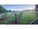 View of rolling green fields surrounded by wooden fencing beneath a serene, partly cloudy sky at 96 Landers Ne Rd, Rydal, GA 30171