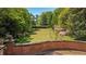 Expansive green backyard with sculpted hedges, flowering trees, and a classic brick retaining wall at 289 W Paces Ferry Nw Rd, Atlanta, GA 30305