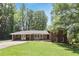 Charming red brick home with a covered carport, lush green lawn, and mature trees at 3007 Octavia Cir, Marietta, GA 30062