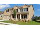 Inviting two-story home featuring a brick facade, covered porch, and well-maintained landscaping at 3325 Linstead Ct, Loganville, GA 30052