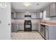Efficient kitchen featuring gray cabinets, black appliances, tile flooring and a functional layout at 939 Redan Trce, Stone Mountain, GA 30088