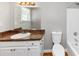 Bathroom showcases a vanity, a toilet, a shower-tub combination, and a large mirror at 1626 Cobbs Creek Ln, Decatur, GA 30032