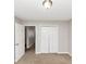 Bedroom with neutral carpet, closet and walls, plus an open door to another room at 1626 Cobbs Creek Ln, Decatur, GA 30032