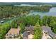 An aerial view showcases the lakefront home surrounded by lush greenery and waterfront views at 4290 Bobbins Way, Cumming, GA 30041