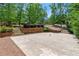 Spacious concrete patio for recreational activities with surrounding mature trees at 4290 Bobbins Way, Cumming, GA 30041