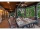 Inviting covered porch boasts a dining table, ceiling fan, and wooded view at 4290 Bobbins Way, Cumming, GA 30041