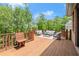 Outdoor wooden deck features stylish seating and a wooded backyard at 4290 Bobbins Way, Cumming, GA 30041