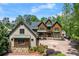 Beautiful home with brick and wood accents, lush landscaping, and a circular driveway at 4290 Bobbins Way, Cumming, GA 30041