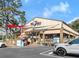 Exterior daytime view of Pig Tales on Lake Lanier, featuring ample parking and outdoor seating at 4290 Bobbins Way, Cumming, GA 30041