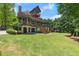 Beautiful back elevation with large manicured lawn and tiered patios at 4290 Bobbins Way, Cumming, GA 30041