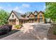 Stately home with a large driveway, lush landscaping, and unique architectural details at 4290 Bobbins Way, Cumming, GA 30041