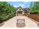Beautiful multi-story home featuring brick, stone, wood, and a sports court surrounded by lush landscaping at 4290 Bobbins Way, Cumming, GA 30041