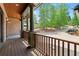 Inviting front porch with wood flooring, stone columns, and a picturesque view of the front yard at 4290 Bobbins Way, Cumming, GA 30041