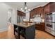 Gourmet kitchen with granite counters, island, stainless appliances, and dark wood cabinetry at 4290 Bobbins Way, Cumming, GA 30041