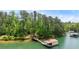 Scenic view of a lake with a private dock and boathouse surrounded by lush green trees at 4290 Bobbins Way, Cumming, GA 30041
