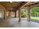 Spacious covered patio with natural stone pillars and wood ceiling overlooking backyard and lake at 4290 Bobbins Way, Cumming, GA 30041