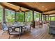 A covered porch with an outdoor kitchen, fireplace, and plenty of seating at 4290 Bobbins Way, Cumming, GA 30041
