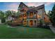 Back of home showcasing multi-tiered decks, stone facade, outdoor lighting, and landscaped yard at 4290 Bobbins Way, Cumming, GA 30041