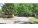 Exterior shot of the house, with a long driveway, mature trees, and a shed at 7580 Blacks Mill Rd, Cumming, GA 30028