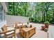 Inviting outdoor space featuring comfortable chairs, rustic wooden coffee table, and lush greenery at 7580 Blacks Mill Rd, Cumming, GA 30028