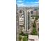 An aerial shot of a tall building nestled among lush greenery and other city highrises at 860 Peachtree Ne St # 2815, Atlanta, GA 30308
