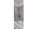 Bathroom features gray tiled walls and a white bathtub with shower curtain and storage ledge at 860 Peachtree Ne St # 2815, Atlanta, GA 30308