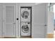 Convenient laundry closet with a stacked washer and dryer unit and storage shelves at 860 Peachtree Ne St # 2815, Atlanta, GA 30308